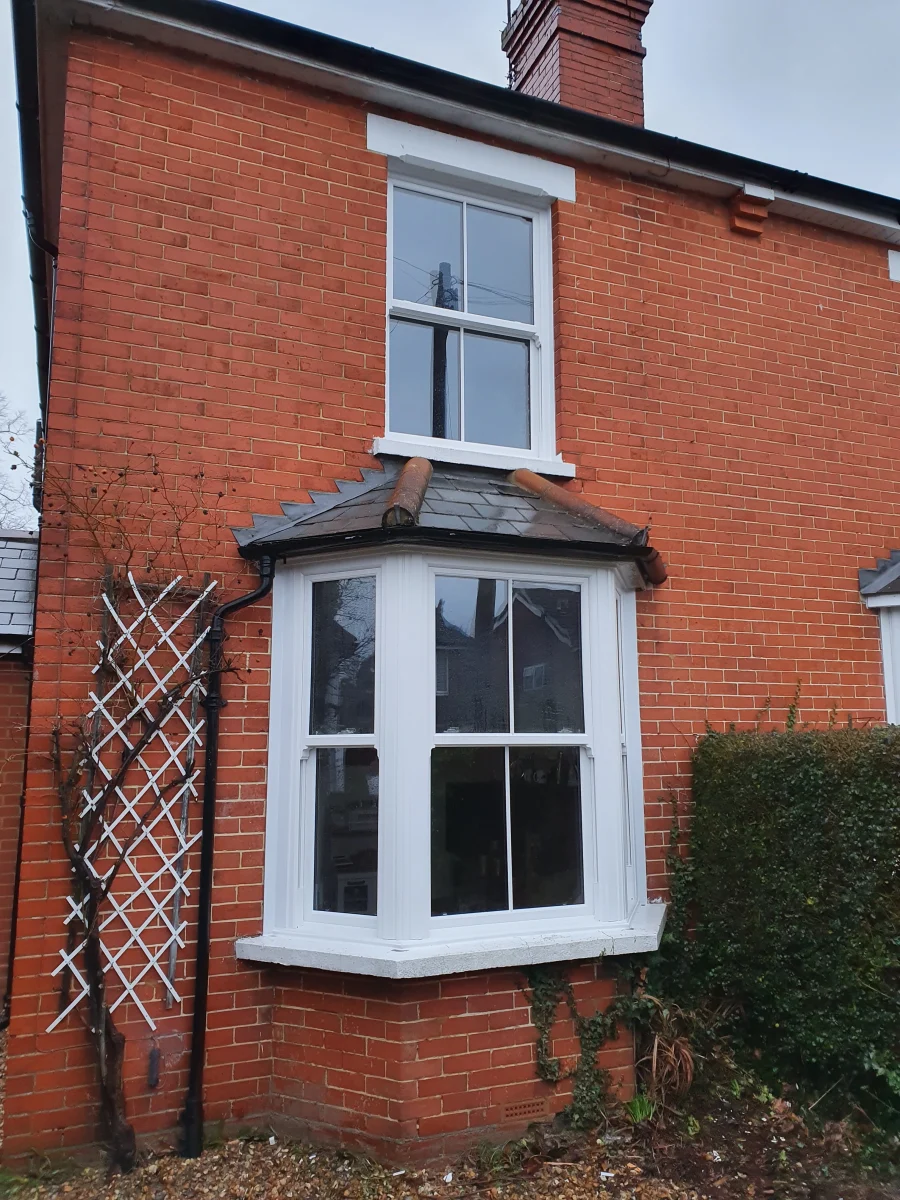three facet bay window with vertical sliders in red brick wall in hampshire