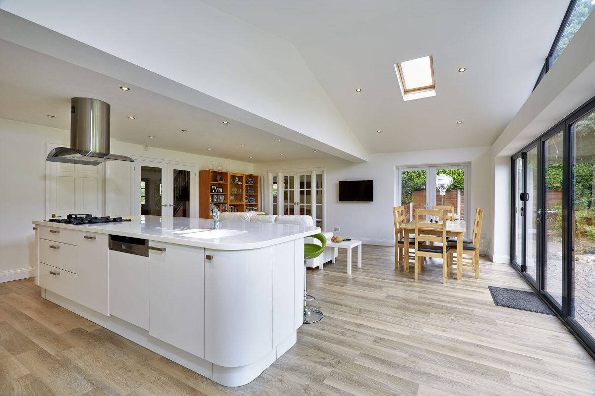 large kitchen in solid conservatory roof extension with grey bifold doors