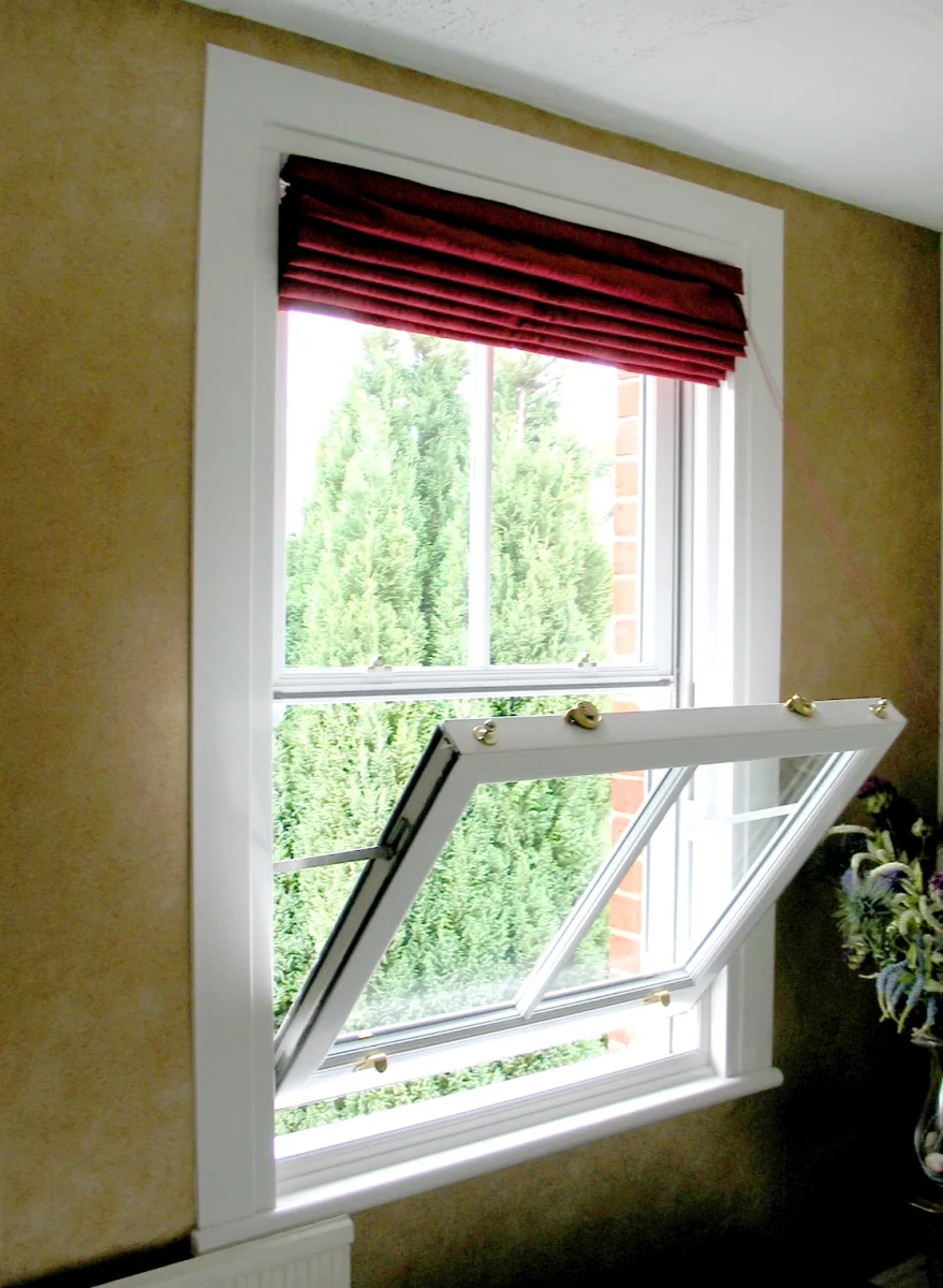 white vertical sliding window tilted for cleaning