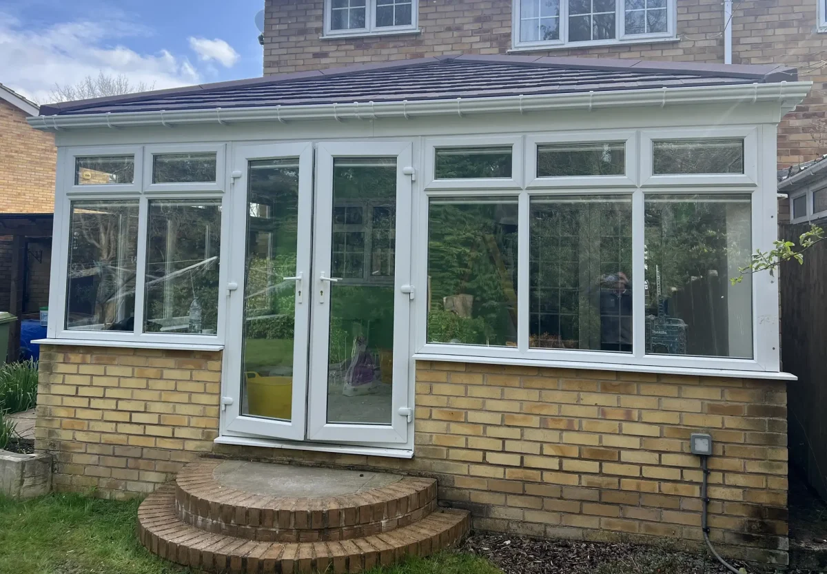 edwardian replacement conservatory roof with burnt umber tiles and french doors