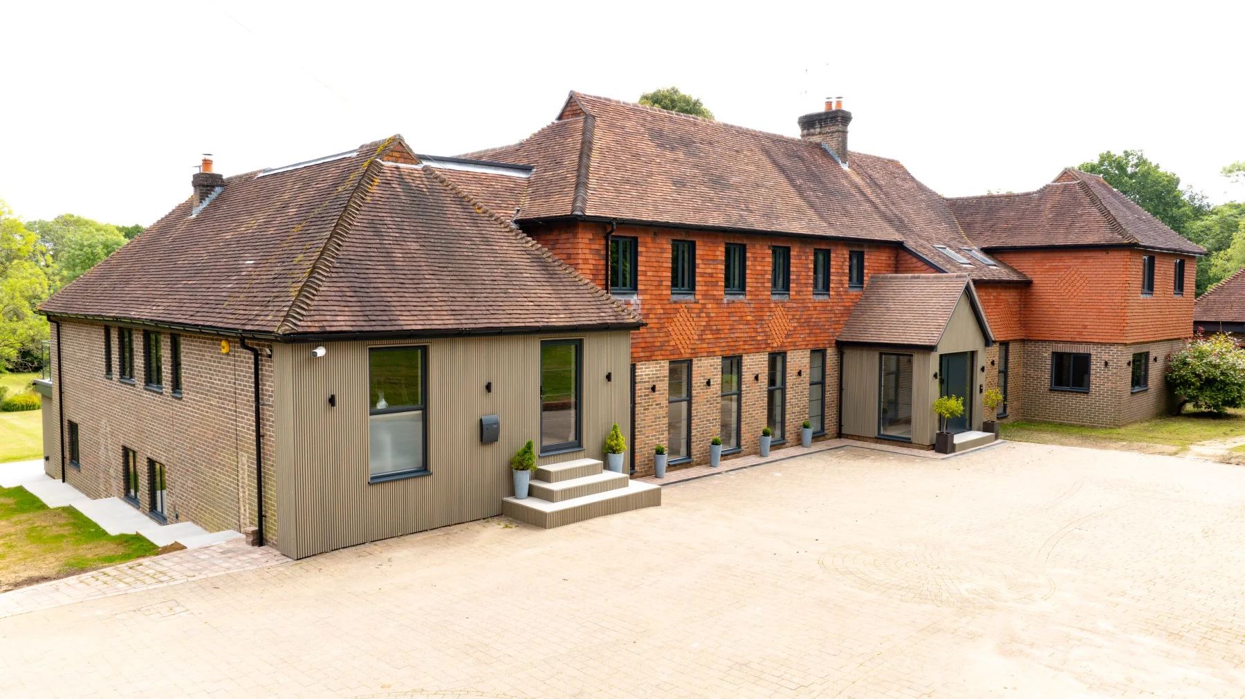 antracite grey aluminium windows in part tiled house