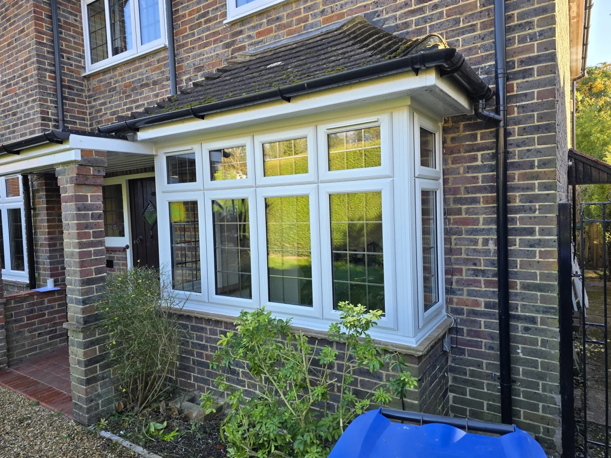 white upvc bay window with square lead glass in brick wall
